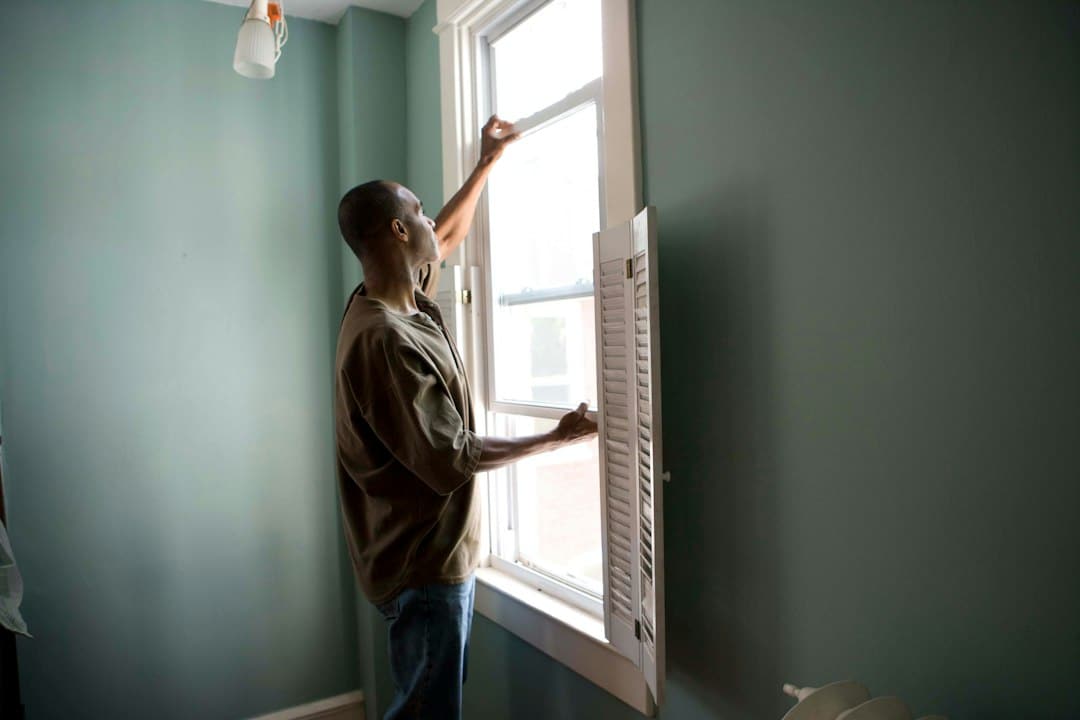 Window contractor inspecting window measurements for rebate compliance